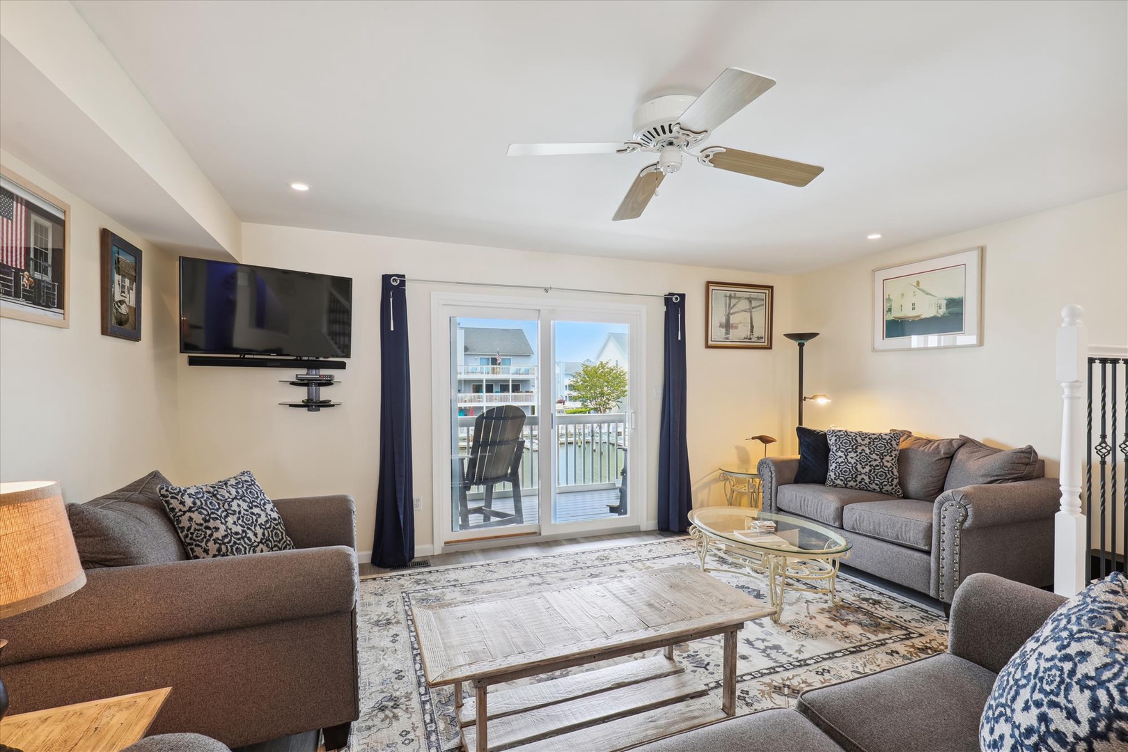 Your spacious living room features plush seating, a wall-mounted TV, and French doors opening to your private balcony, creating a bright and welcoming retreat for relaxation.