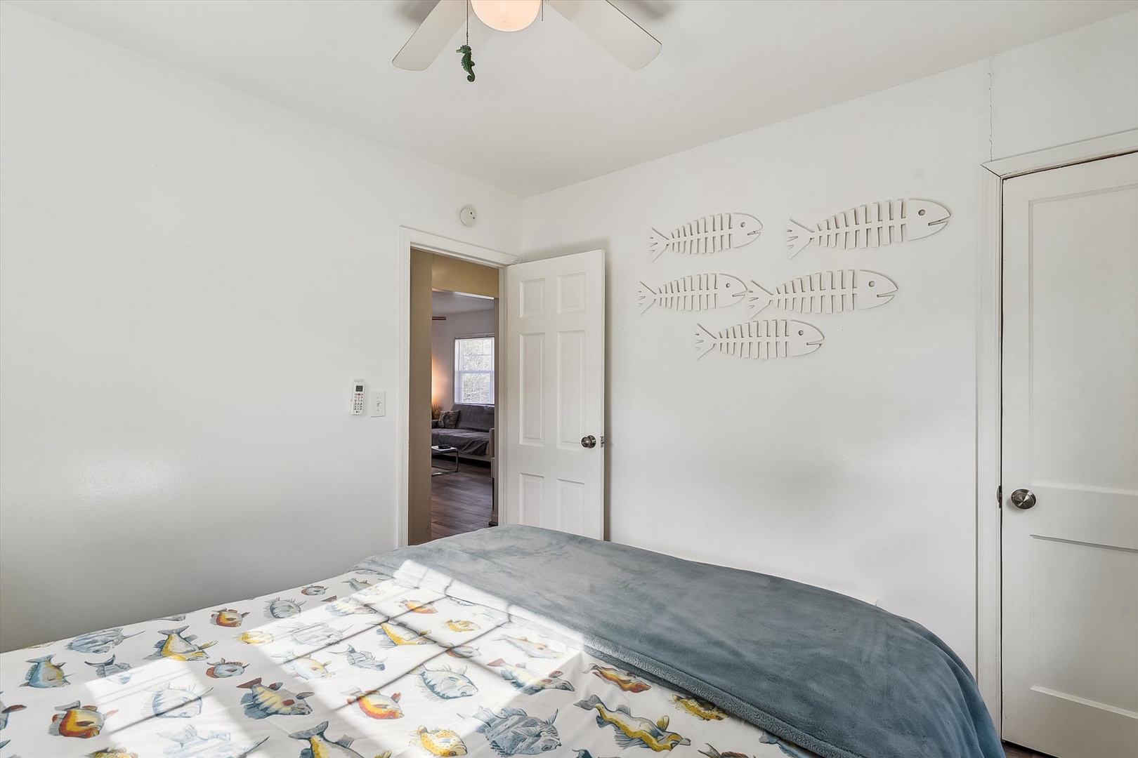 This cozy bedroom invites you to rest with its soft bedding and cheerful coastal decor. Natural light flows in, while the ceiling fan keeps you comfortable year-round.