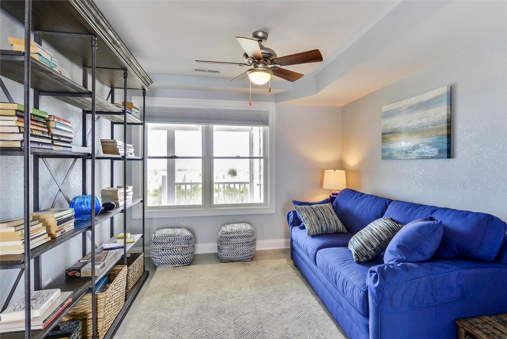 Curl up on the plush blue sofa and enjoy a good book from your personal library. The ceiling fan keeps you cool while natural light streams through your window.