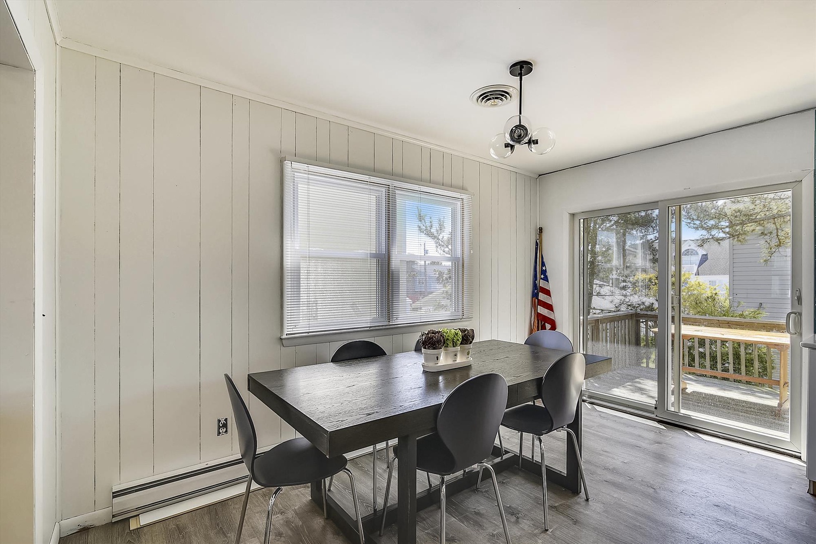 Gather around this inviting dining table with natural light streaming through large windows, perfect for your morning coffee or evening meals together.