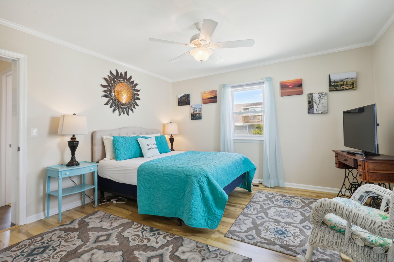 Step into your bright, cheerful bedroom with a plush bed dressed in turquoise accents, soft lighting, and gentle ocean breezes from the nearby coast. Your cozy retreat awaits.