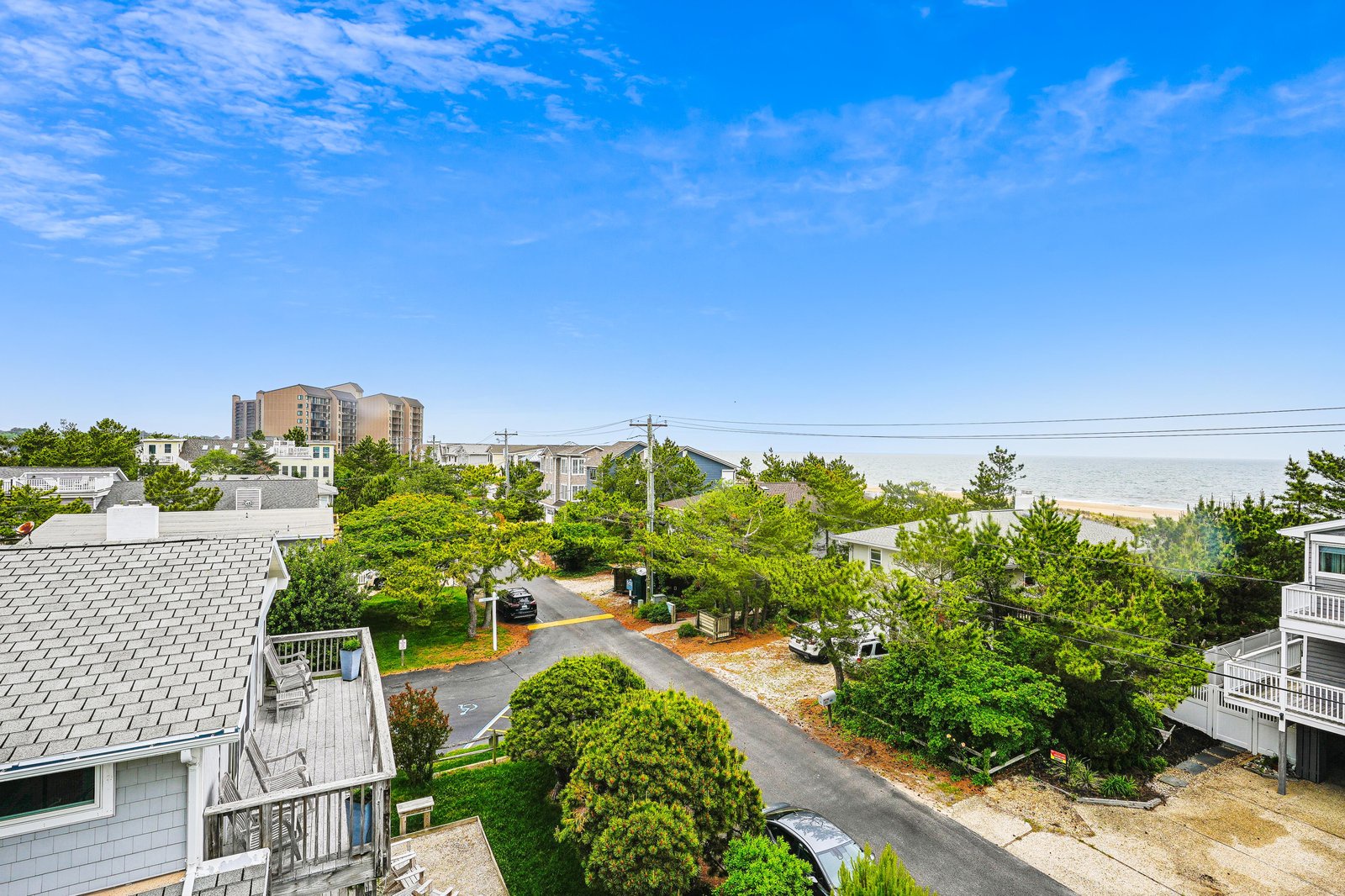 This coastal property sits in a quiet beach neighborhood, with distant ocean views and easy access to the sandy shore just beyond the dunes.