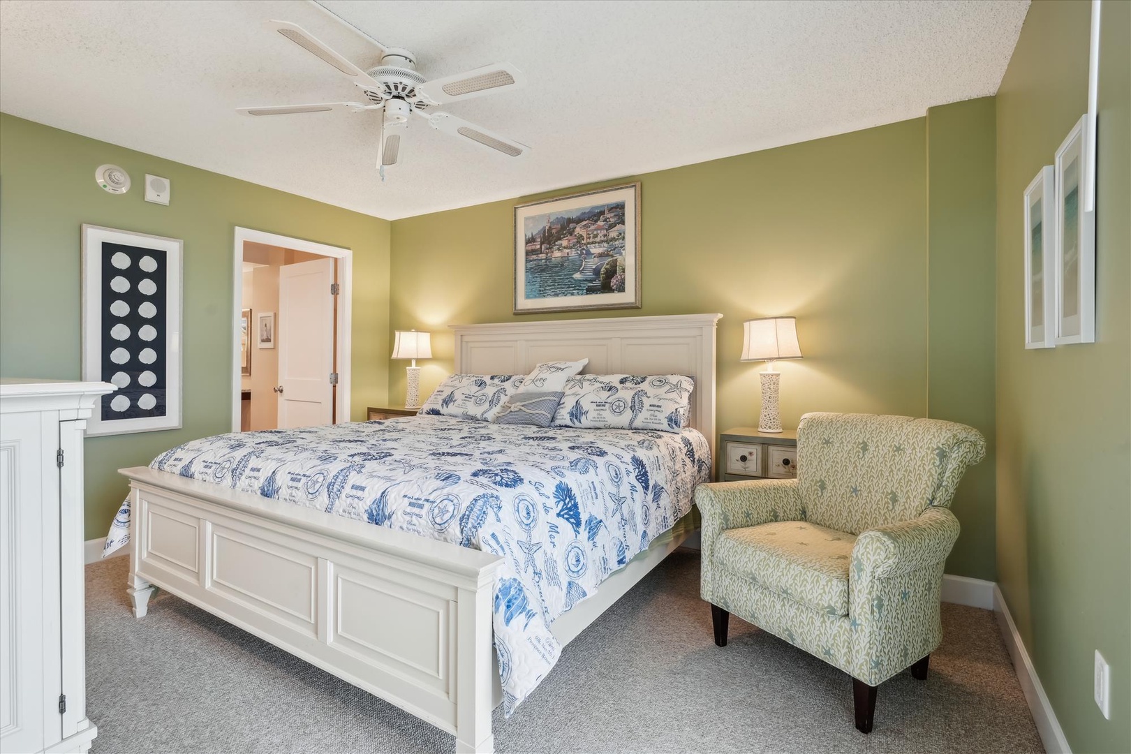 Rest peacefully in your serene retreat with soft green walls, comfortable seating, and gentle ceiling fan creating the perfect ambiance.