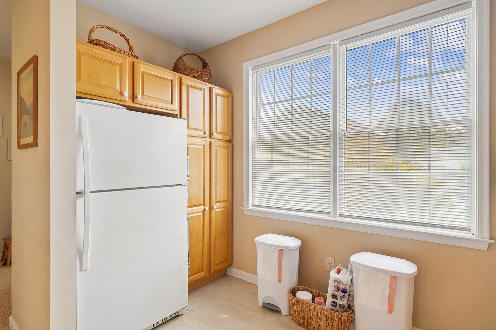 A practical laundry space with natural light, handy cabinetry, and storage for your daily needs.