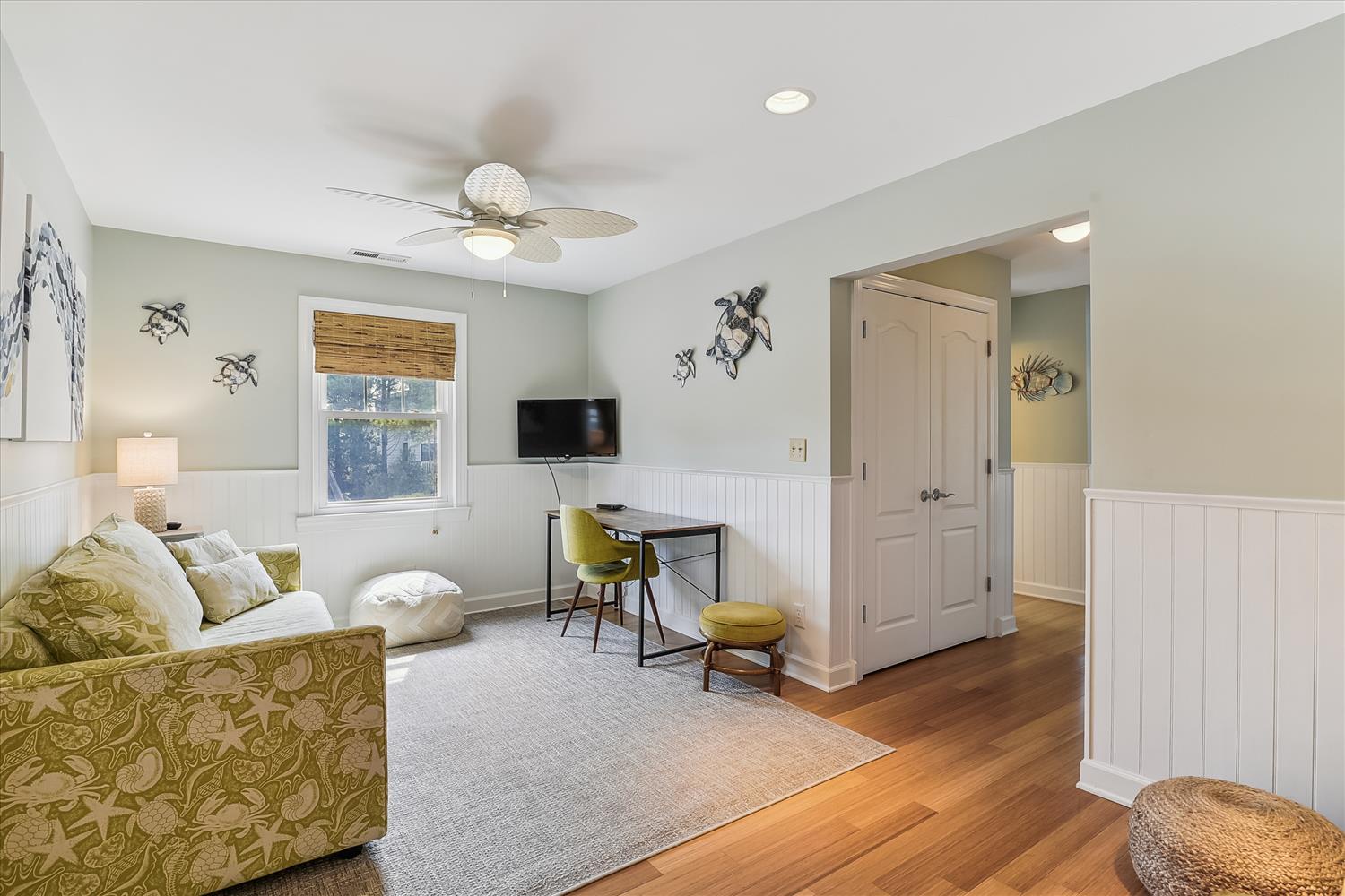 Settle into this coastal-chic living space with cheerful green palm-print furnishings, warm wood floors, and gentle sea turtle accents that set a relaxed, beachy mood for your getaway.