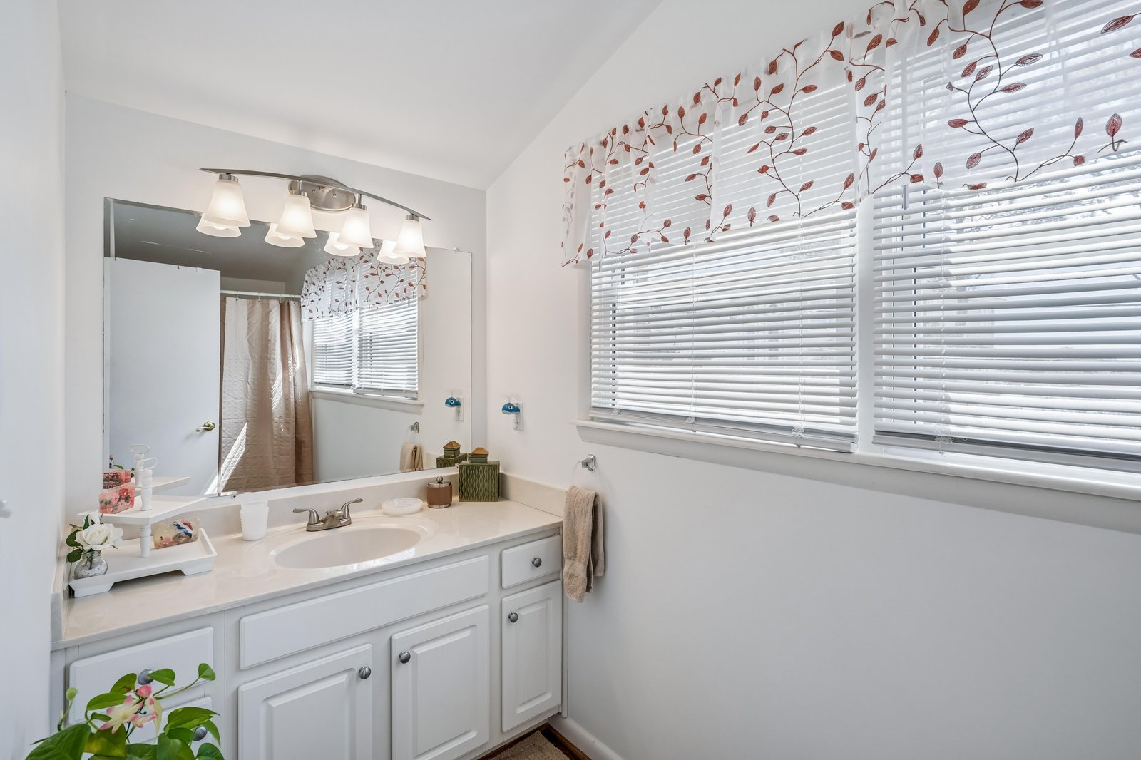Step into your bright, refreshed bathroom featuring a spacious vanity, elegant mirror, and beautiful natural light streaming through the windows—perfect for unwinding after a day of adventure.