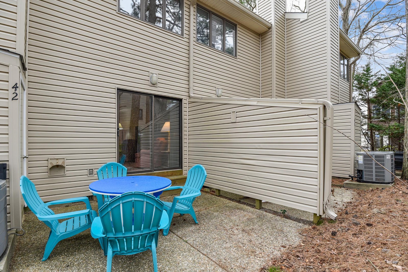 Step outside to your own private patio, where bright blue seating invites you to unwind with morning coffee or an evening chat under the open sky.