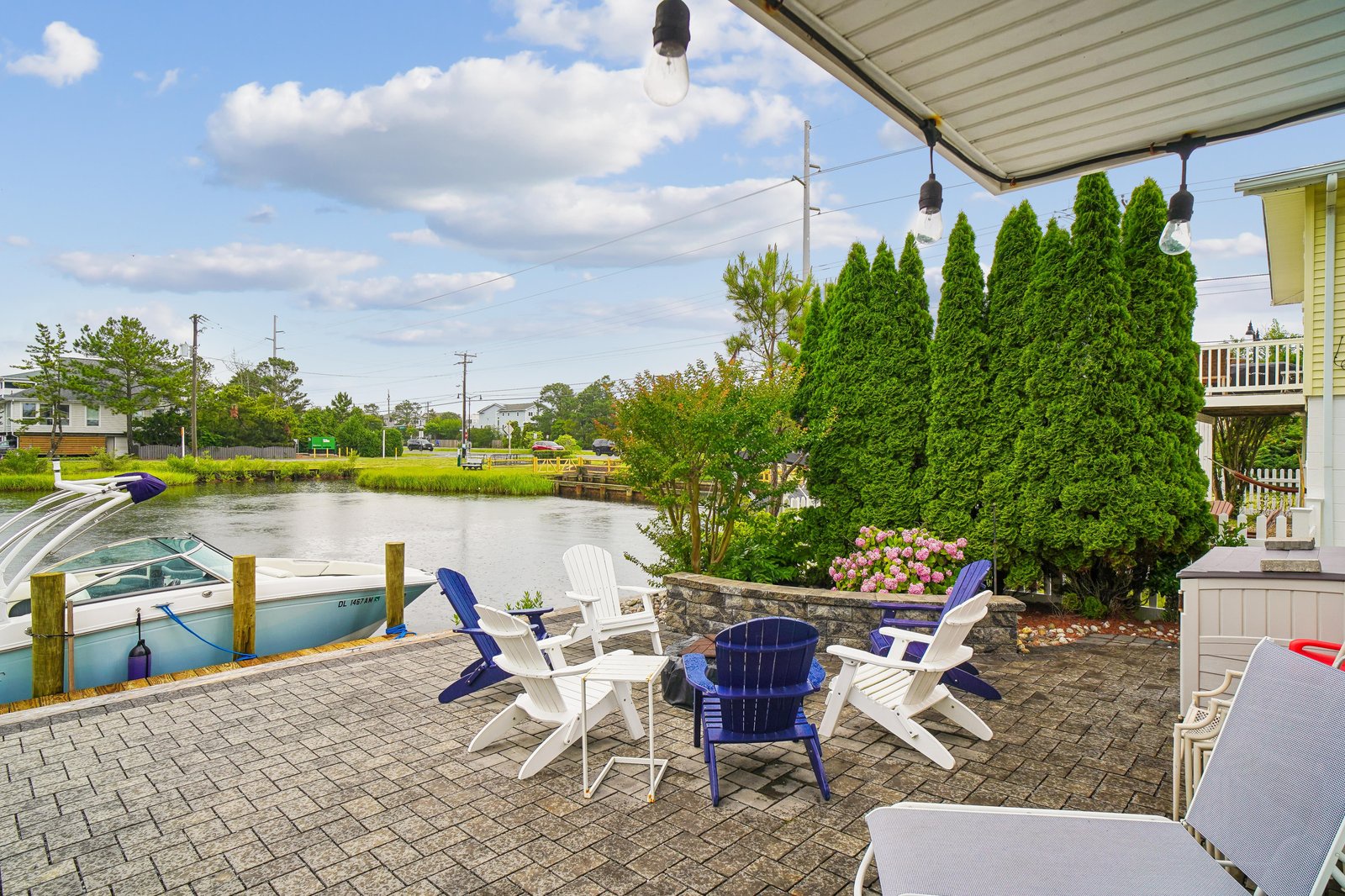 Gather on your private waterfront patio with cozy seating for morning coffee or evening conversation. Enjoy direct canal access with your own boat slip, surrounded by lush greenery and peaceful water views.