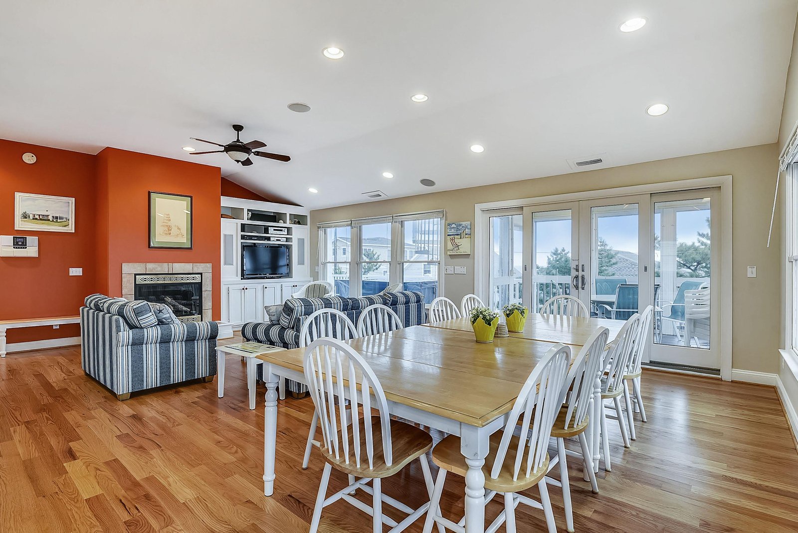 Gather around the spacious dining table for meals with stunning water views through the glass doors, or relax in the cozy living area with coastal charm and a warm fireplace.