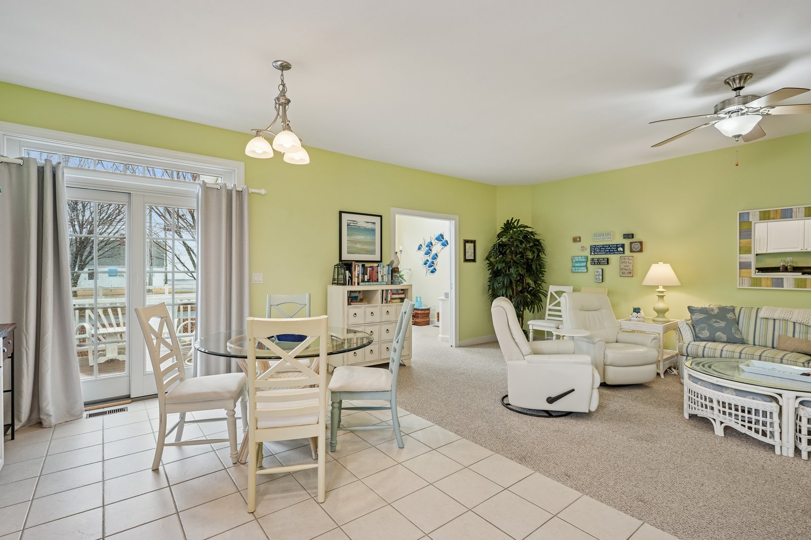 Step into your bright, cheerful open living space where lime green walls and coastal decor create a refreshing beach-house vibe for your getaway.