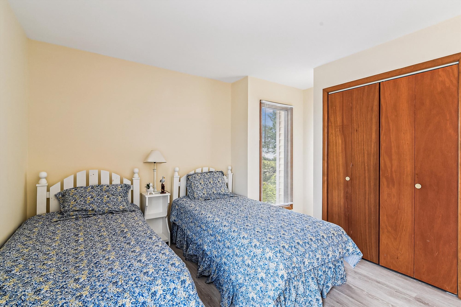 Twin beds with charming blue floral linens invite peaceful rest, while warm wood closets offer ample storage for your belongings throughout your stay.