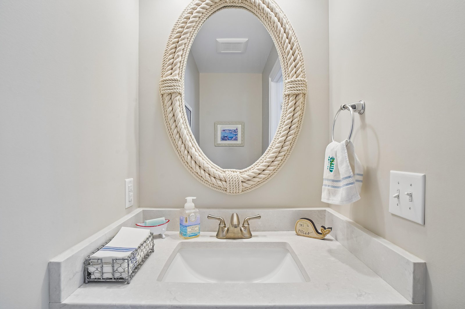 Refresh in your own coastal-inspired bathroom with a rope-framed mirror and fresh towels waiting for you.