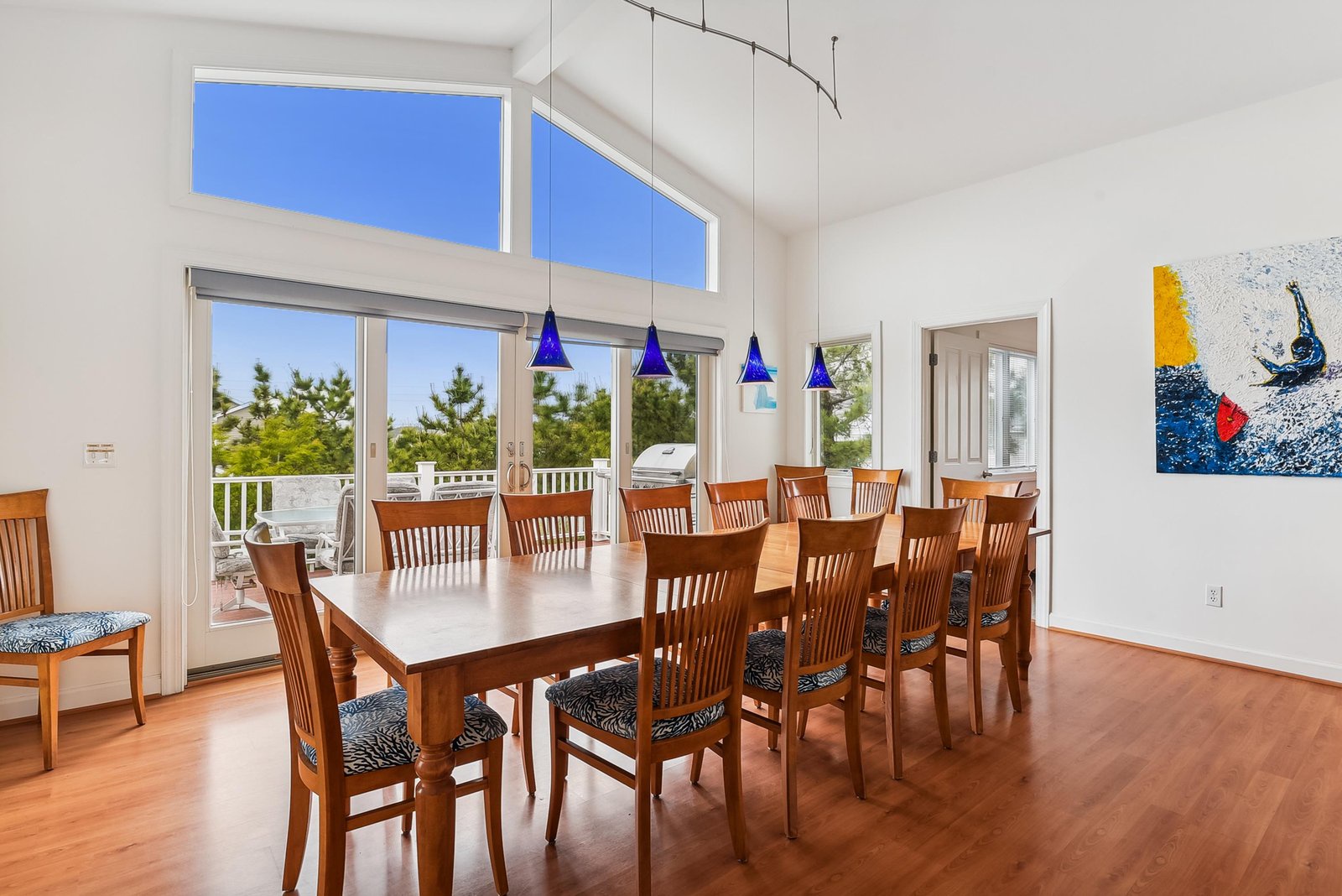 Gather everyone at this elegant table where bright pendant lights and natural daylight create the perfect atmosphere for memorable meals together. Large glass doors open to your private deck, inviting fresh air and views into your dining experience.
