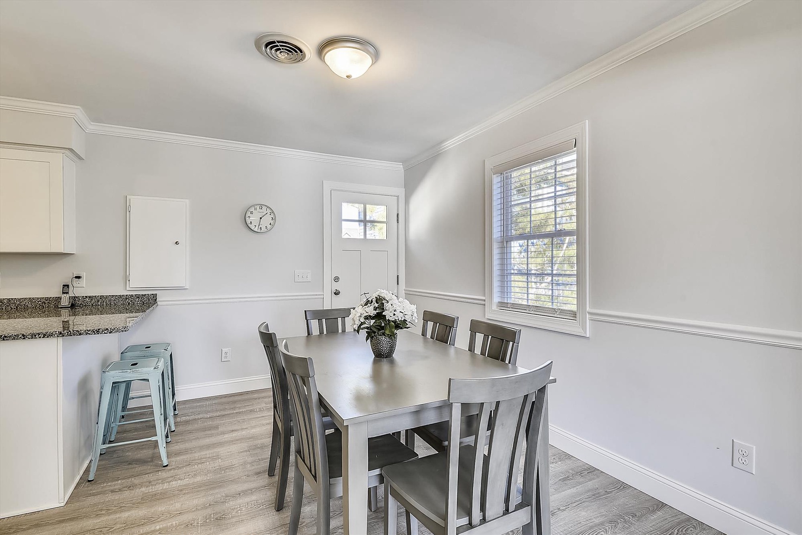 Enjoy meals together at your spacious dining table with natural light streaming through large windows in this bright, welcoming space.