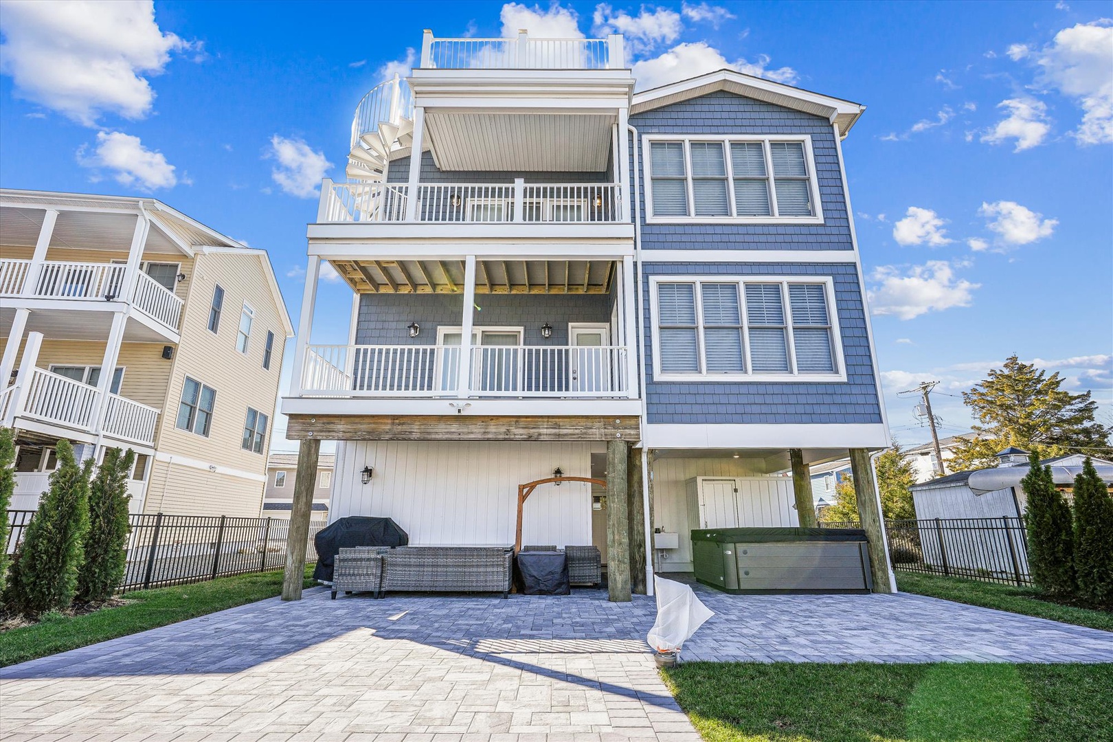 A coastal three-story property featuring spacious balconies, private parking, and a convenient ground-level entrance in a residential beach community.