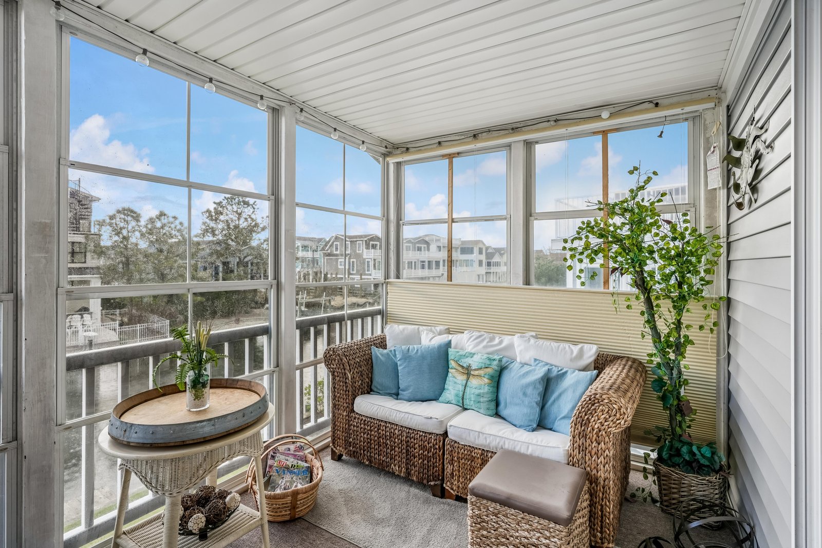 Picture yourself unwinding here with your morning coffee, surrounded by soft coastal breezes and natural light. This inviting screened porch offers comfortable seating and serene neighborhood views, perfect for your quiet moments.