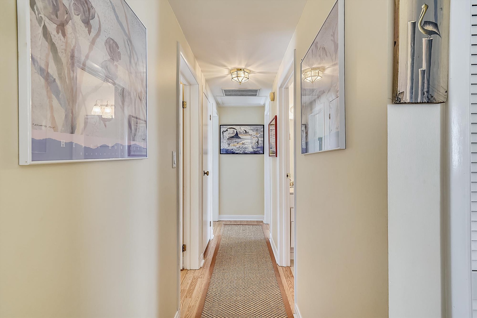 Elegant hallway with warm lighting and curated art guides you to comfortable private spaces, where your relaxation awaits just steps away.