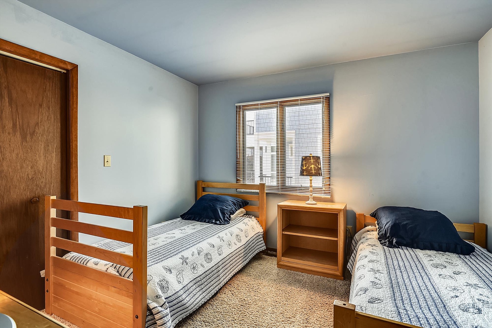 Two comfortable twin beds and soft blue walls create a restful retreat where you can unwind after exploring. Natural light and simple furnishings make this your perfect home base.