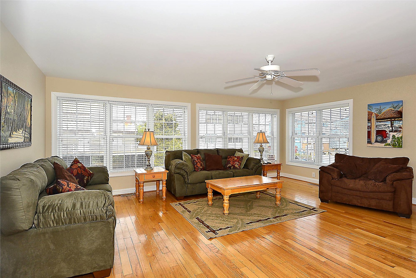 Unwind in your sunlit living room with gleaming hardwood floors, plush seating for everyone, and bright windows that fill the space with natural warmth and charm.