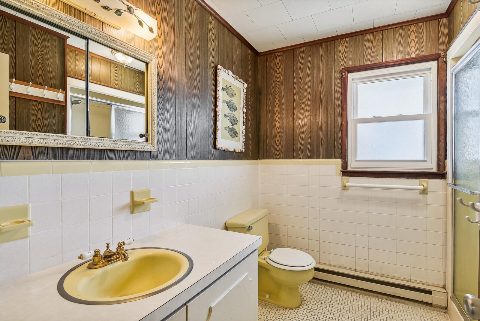 Vintage charm meets functionality in your private bathroom, featuring classic wood paneling and cheerful yellow fixtures that add character to your stay.