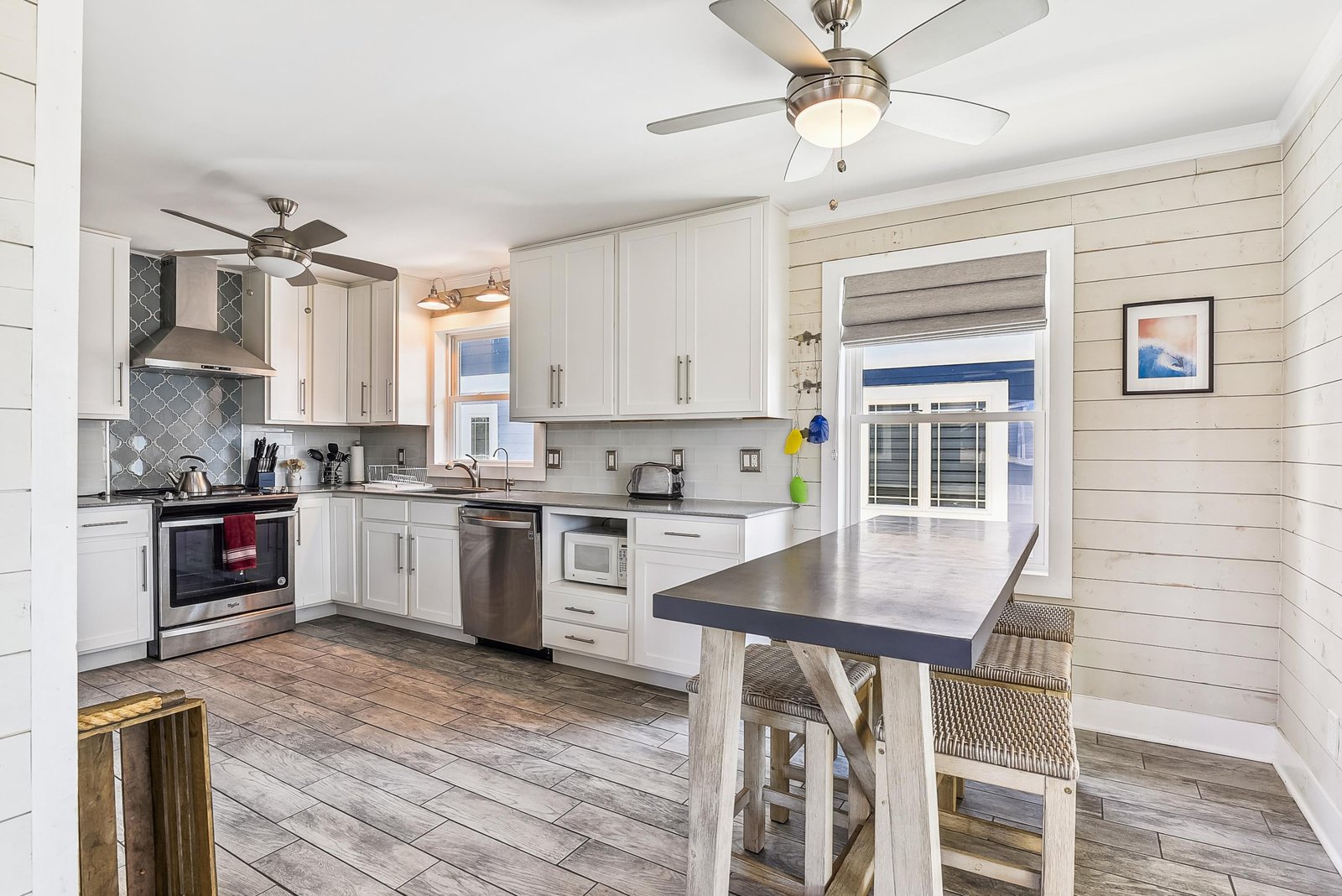 Your bright coastal kitchen awaits, fully equipped with modern appliances and a charming island perfect for morning coffee or meal prep as ocean breezes flow through.