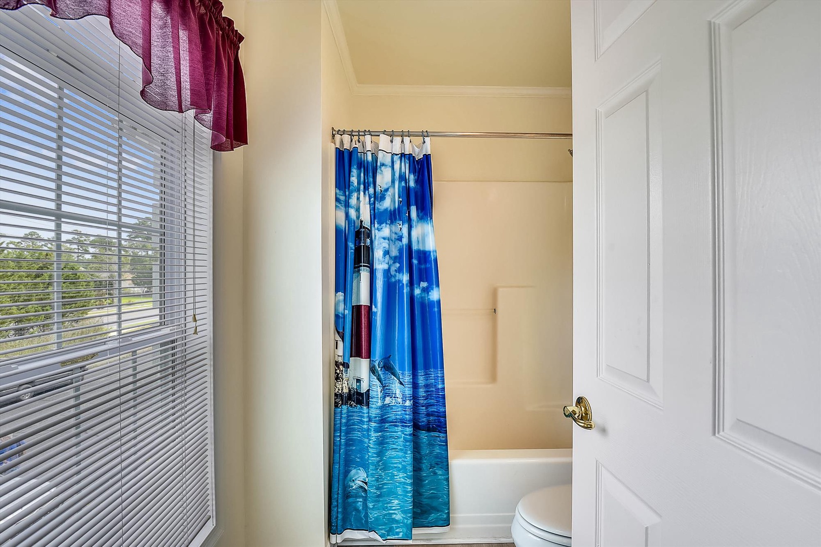Bright, clean bathroom with coastal-themed shower curtain bringing a touch of seaside charm to your private space.