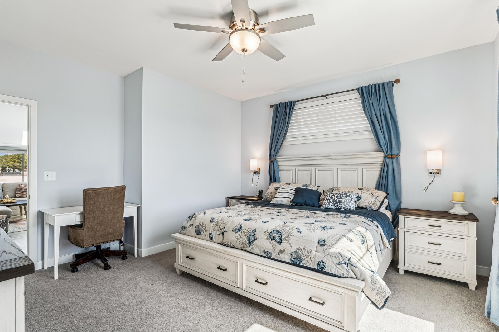 Slip into comfort in this serene bedroom with coastal-inspired linens and gentle sea breezes from your ceiling fan. The desk makes it easy to plan your next adventure without leaving your peaceful retreat.