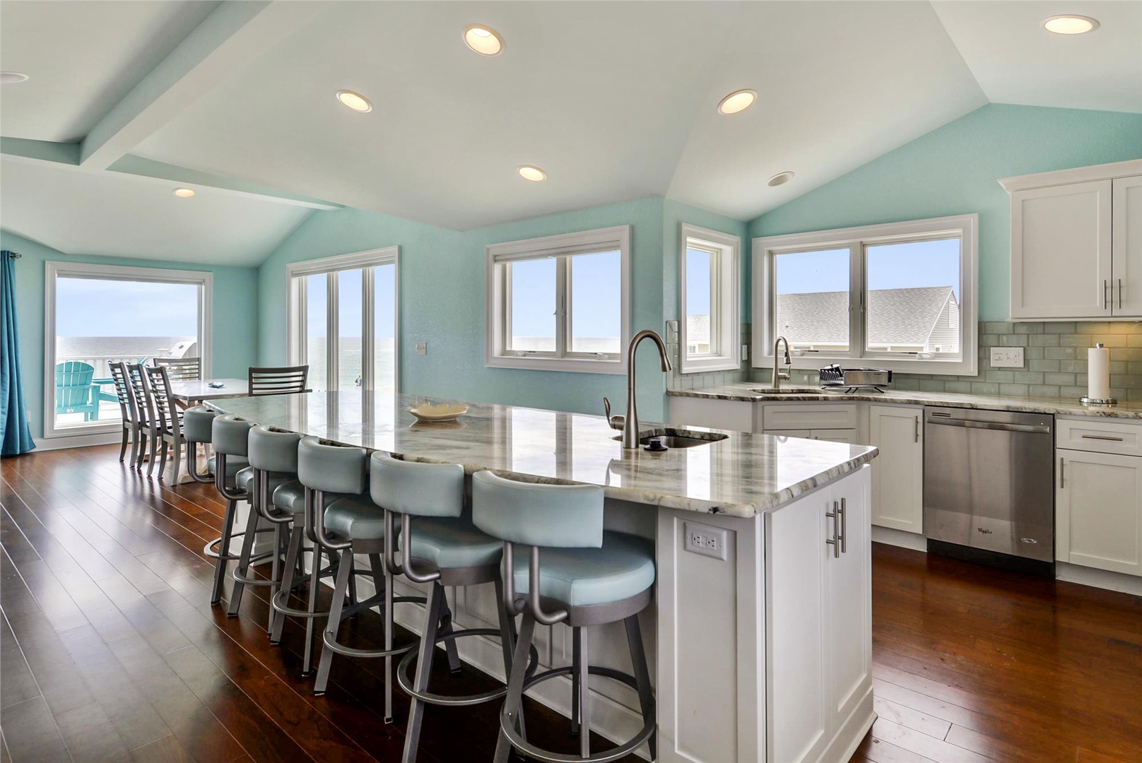 Gather around this spacious island with friends and family, where sleek countertops and modern appliances make meal prep a breeze. Natural light pours through every window, framing serene water views.