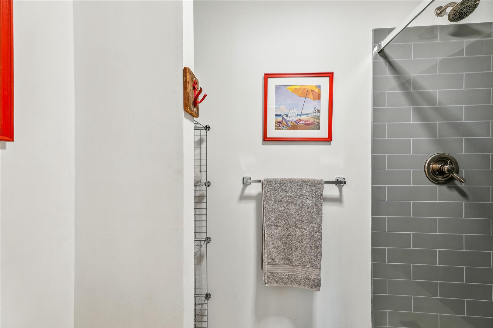 Refresh yourself in this modern walk-in shower with sleek gray subway tile, a rainfall showerhead, and soft towels waiting for you.