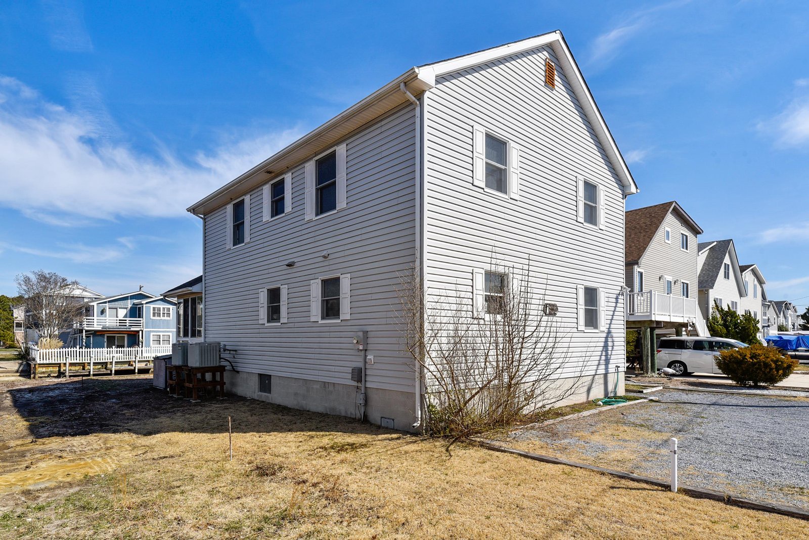 A bright two-story coastal home with classic siding sits in a residential neighborhood, offering easy access to nearby beaches and local attractions.