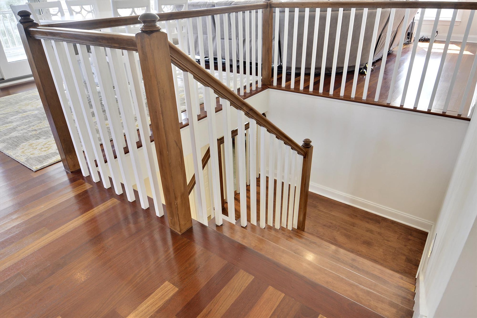 Elegant staircase with rich hardwood floors and classic railing connects the spacious multi-level living areas, adding warmth and character to your home away from home.