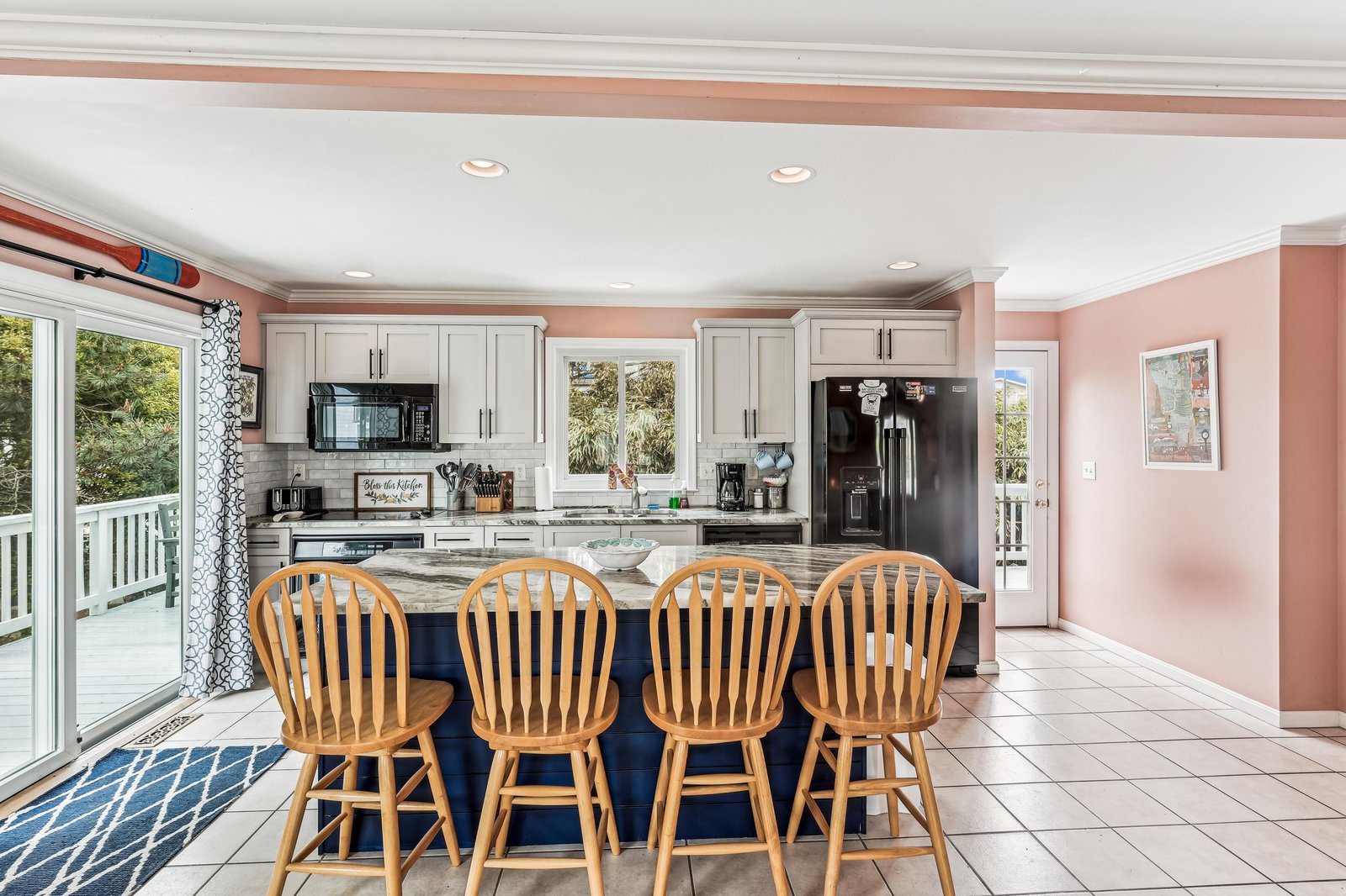 Gather around the generous center island where you can cook, chat, and create memories together in this sun-filled kitchen with modern appliances and plenty of counter space.