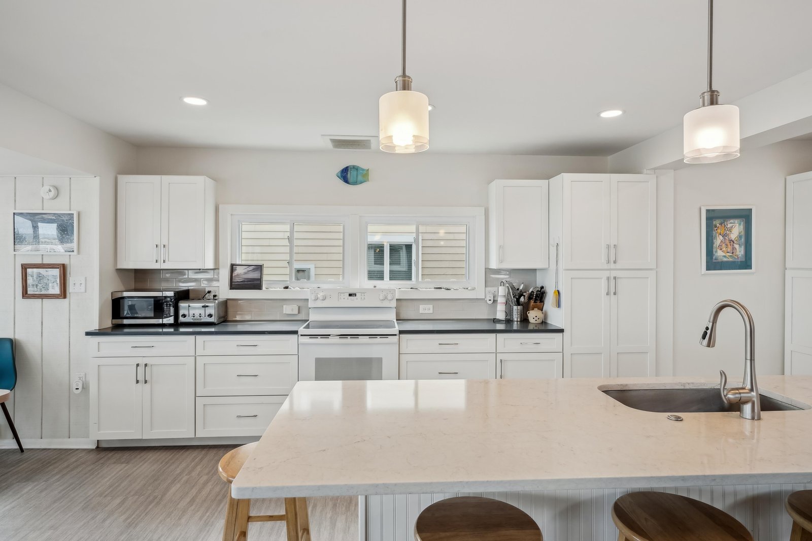 A bright, modern kitchen with crisp white cabinetry and a spacious island invites you to gather and prepare meals in style.