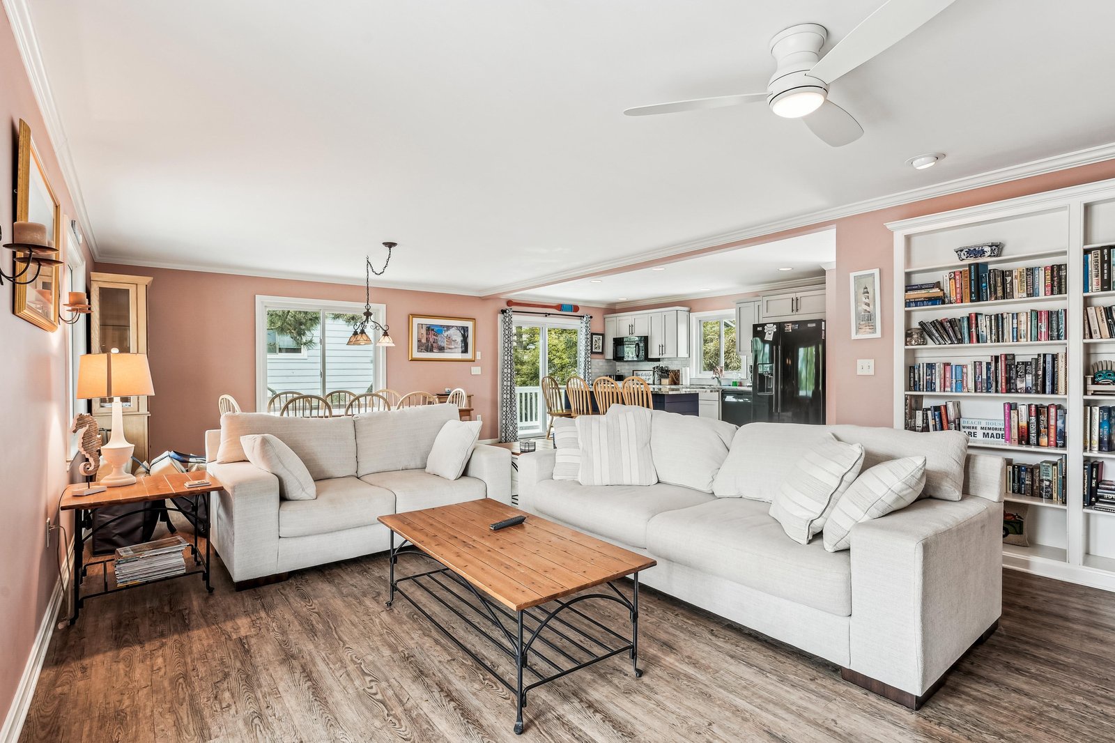 Sink into plush seating and lose yourself in a good book from the built-in library, or gather around for movie night in this bright, open-concept living space that flows seamlessly into the kitchen.