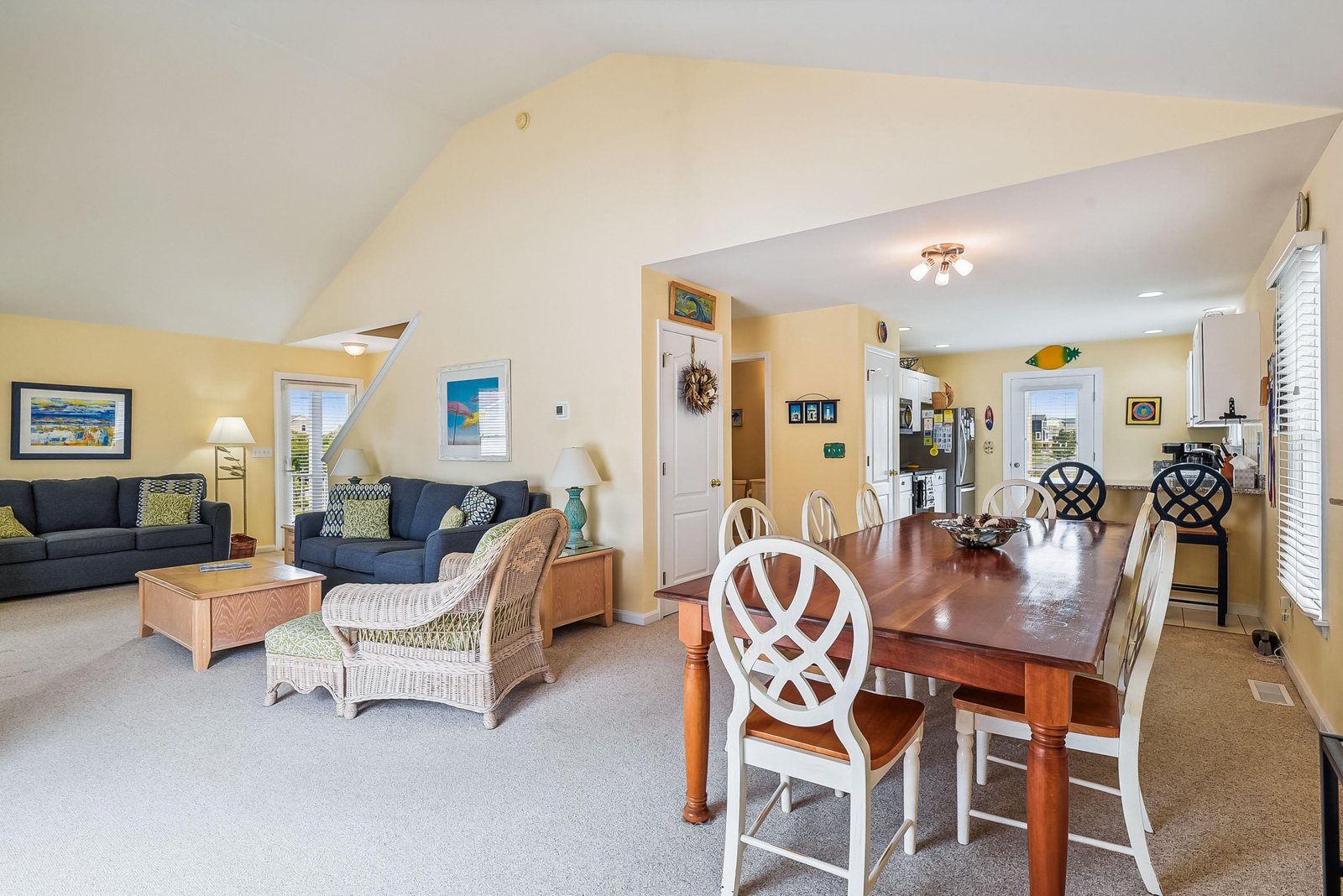 Step into your coastal retreat, where cozy seating and a spacious dining table invite you to gather, relax, and enjoy home-cooked meals in a sun-drenched, cheerful space.
