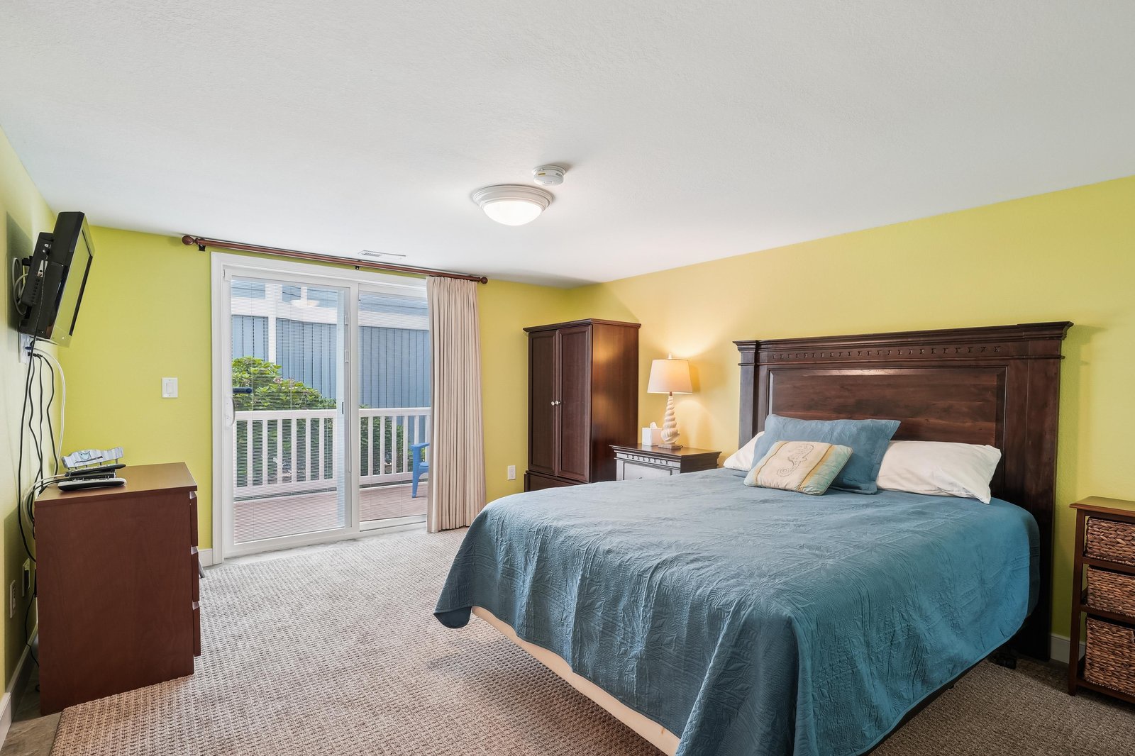Wake up in this bright, coastal bedroom with fresh linens and charming decor. Step out onto your private balcony to savor the peaceful outdoor views and start each day feeling refreshed.