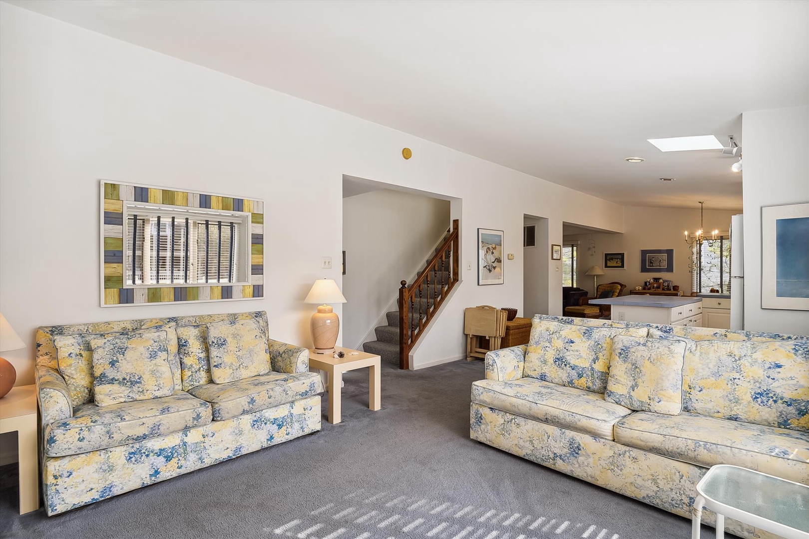 Settle into soft floral sofas in your spacious living room, where warm natural light and open flow to the dining area create the perfect space to unwind after your day.