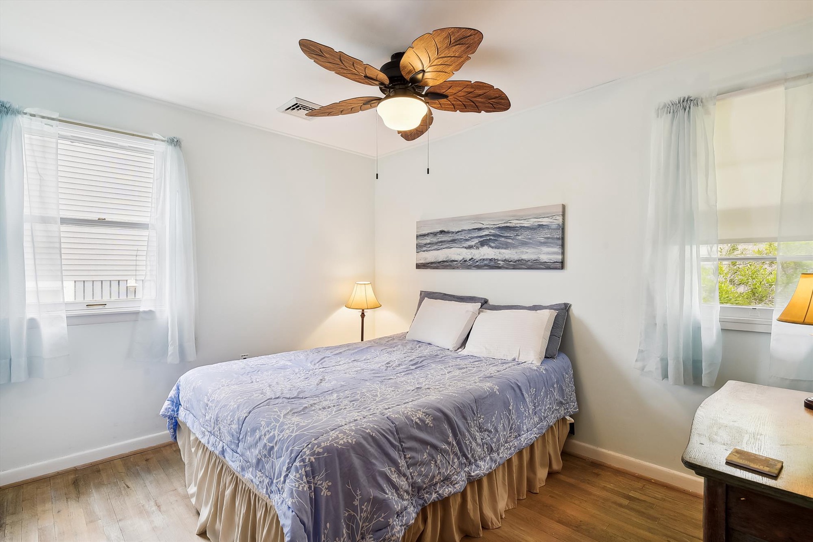 Drift off in this serene bedroom where soft ocean breezes from your ceiling fan and coastal artwork set the stage for your perfect getaway dreams.