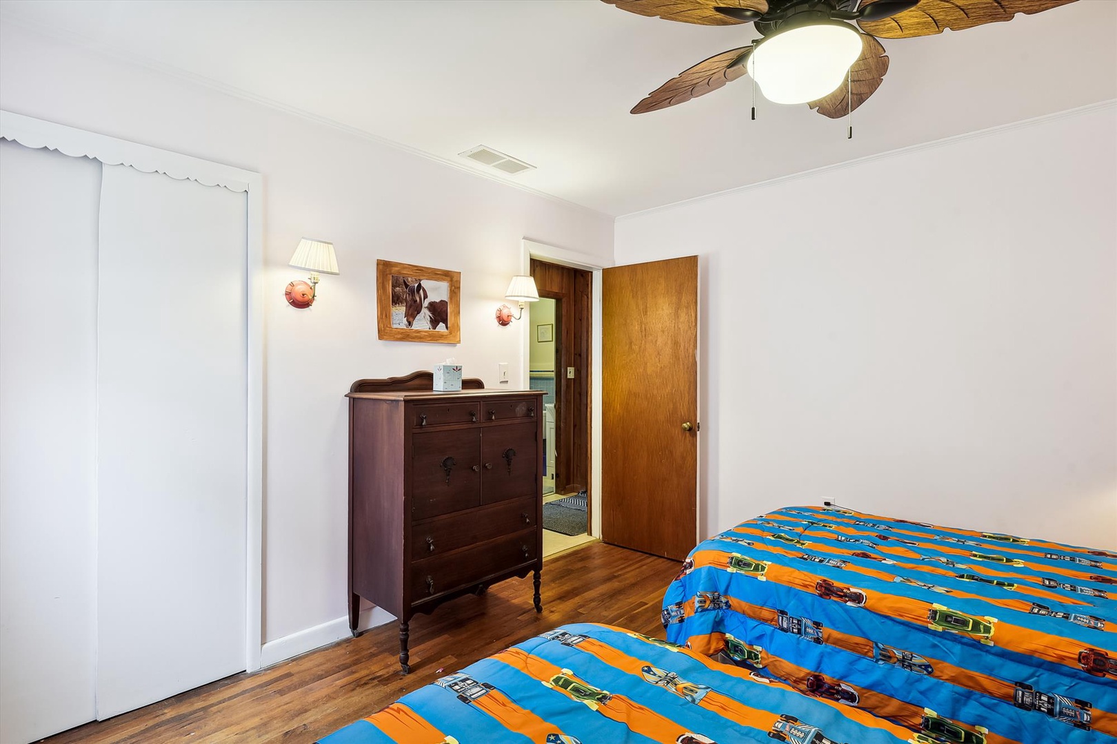 Your cozy retreat features warm wood floors, a charming antique dresser, and a tropical ceiling fan to keep you comfortable during your stay.