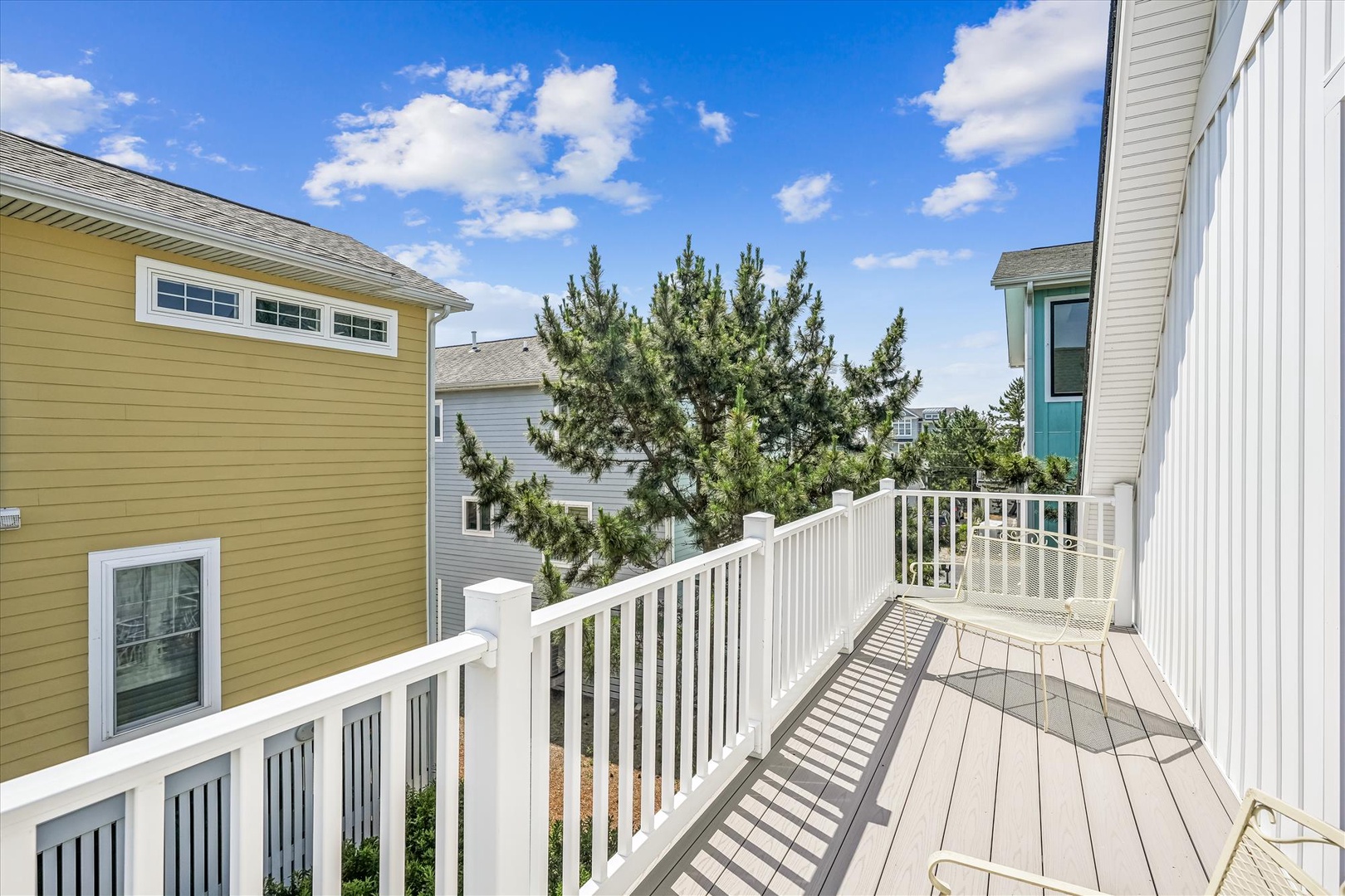 Sunny private balcony with coastal views and bright blue skies, offering a peaceful outdoor retreat for morning coffee or evening relaxation.