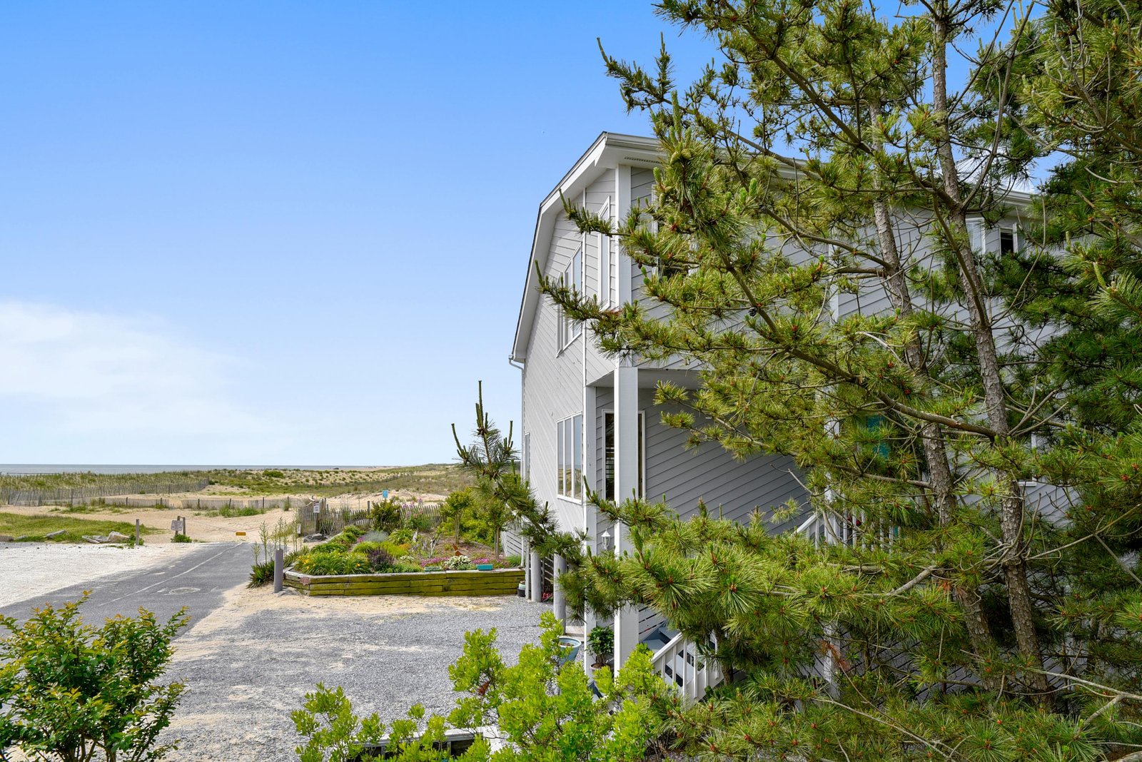 A coastal property set among towering pines, just steps from sandy shores and peaceful marshlands—a serene retreat where natural beauty meets easy beach access.