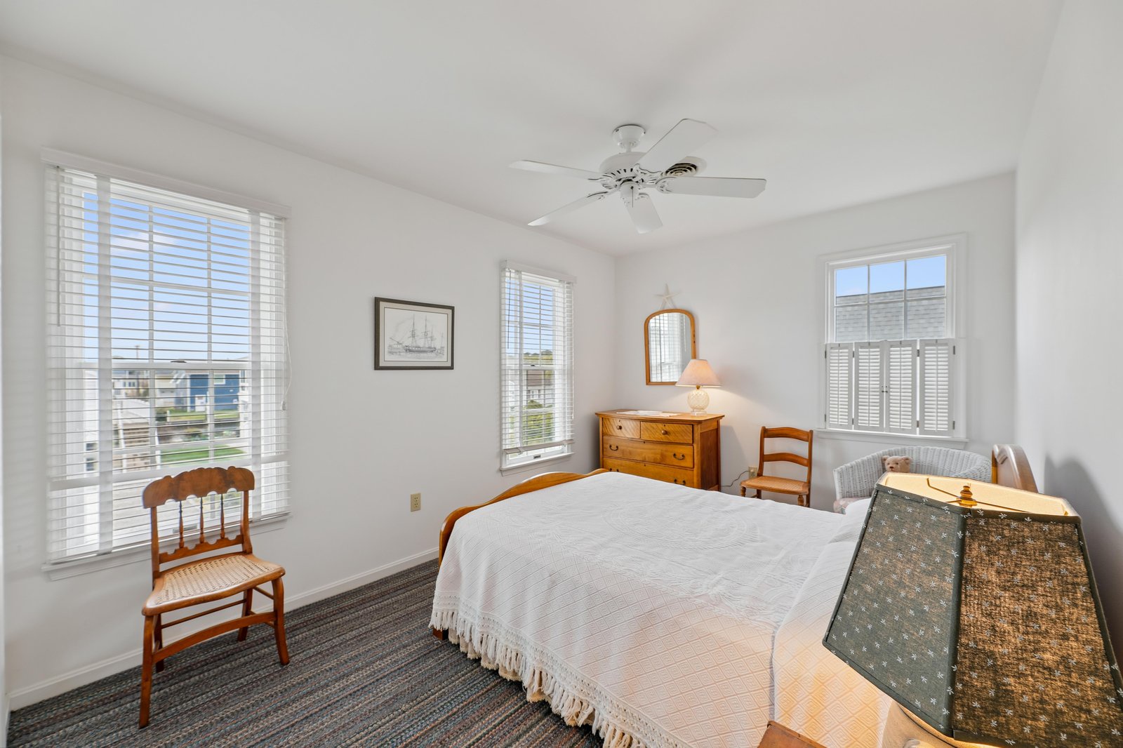 Drift into serene rest in your peaceful bedroom with bright windows and warm coastal charm.