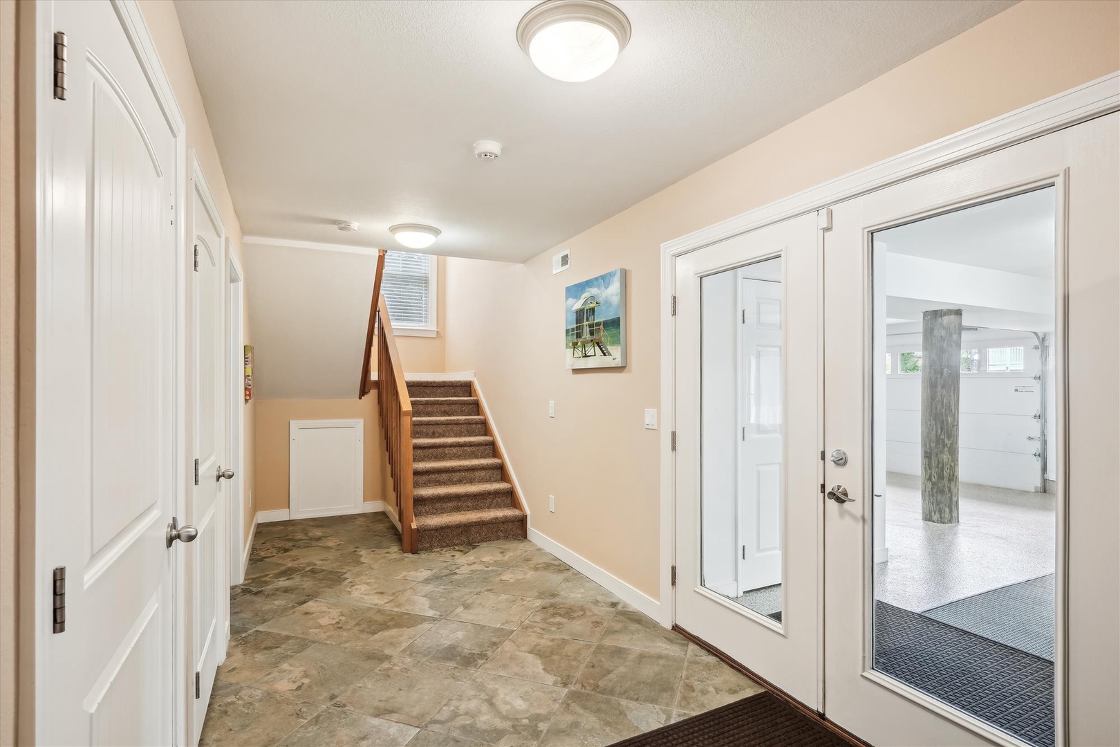 Step into your bright, welcoming entryway with durable tile floors, warm lighting, and easy access to all areas—your beach getaway starts here.