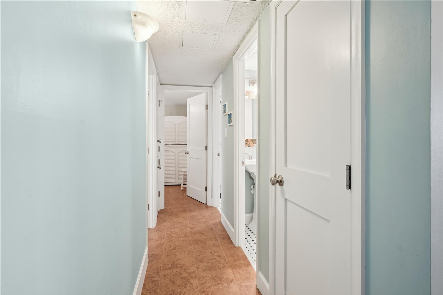 A peaceful hallway invites you to explore your space, with warm cork flooring and soft blue walls creating a calming atmosphere throughout your rental.