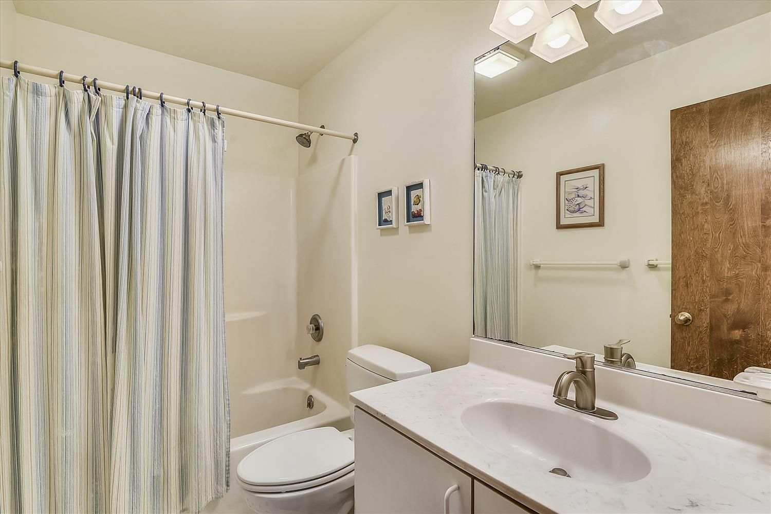 Refresh in your private bathroom featuring a full tub-shower combo, vanity with marble countertop, and thoughtful details for a comfortable stay.