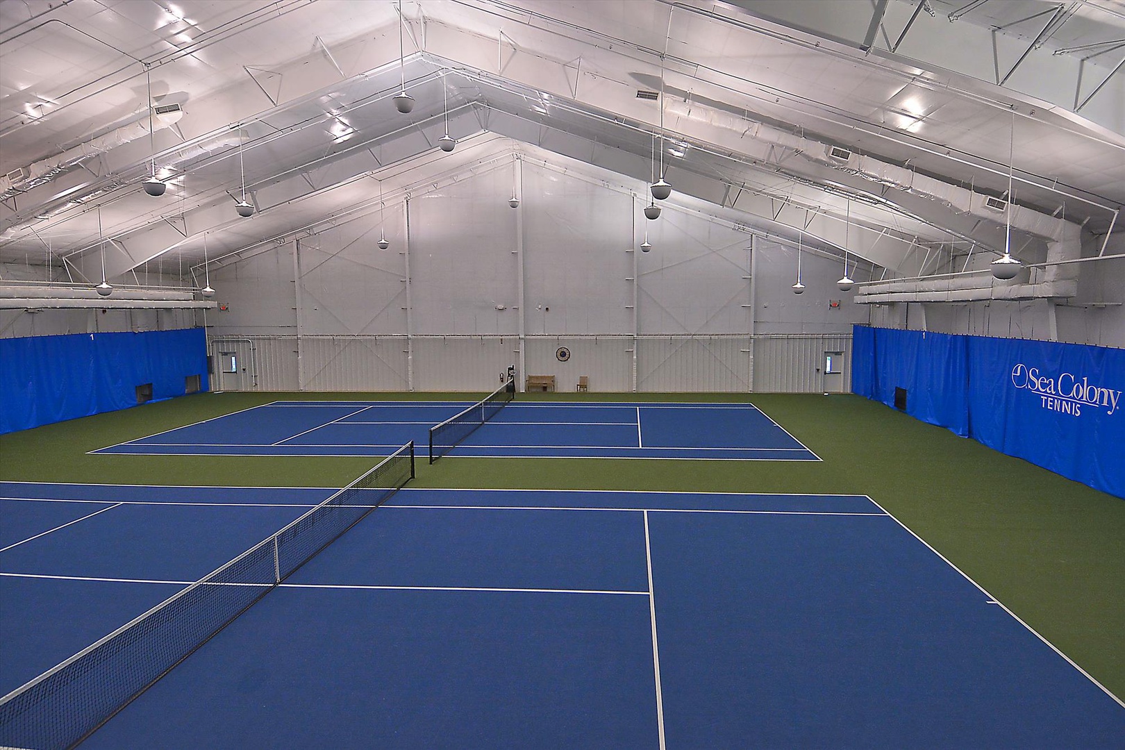 Step into your private tennis haven with two pristine courts under soaring ceilings, where you can perfect your serve rain or shine.