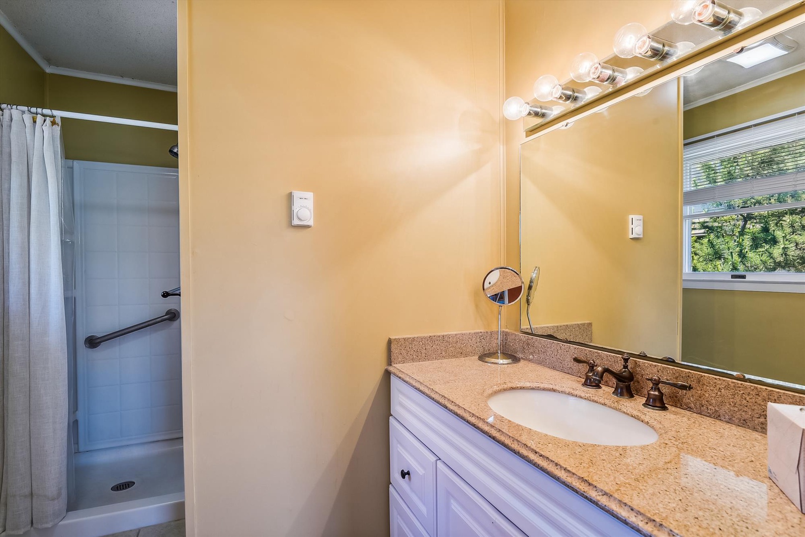 Your private bathroom features warm lighting, granite counters, and a spacious walk-in shower—ideal for refreshing after a day of exploring.