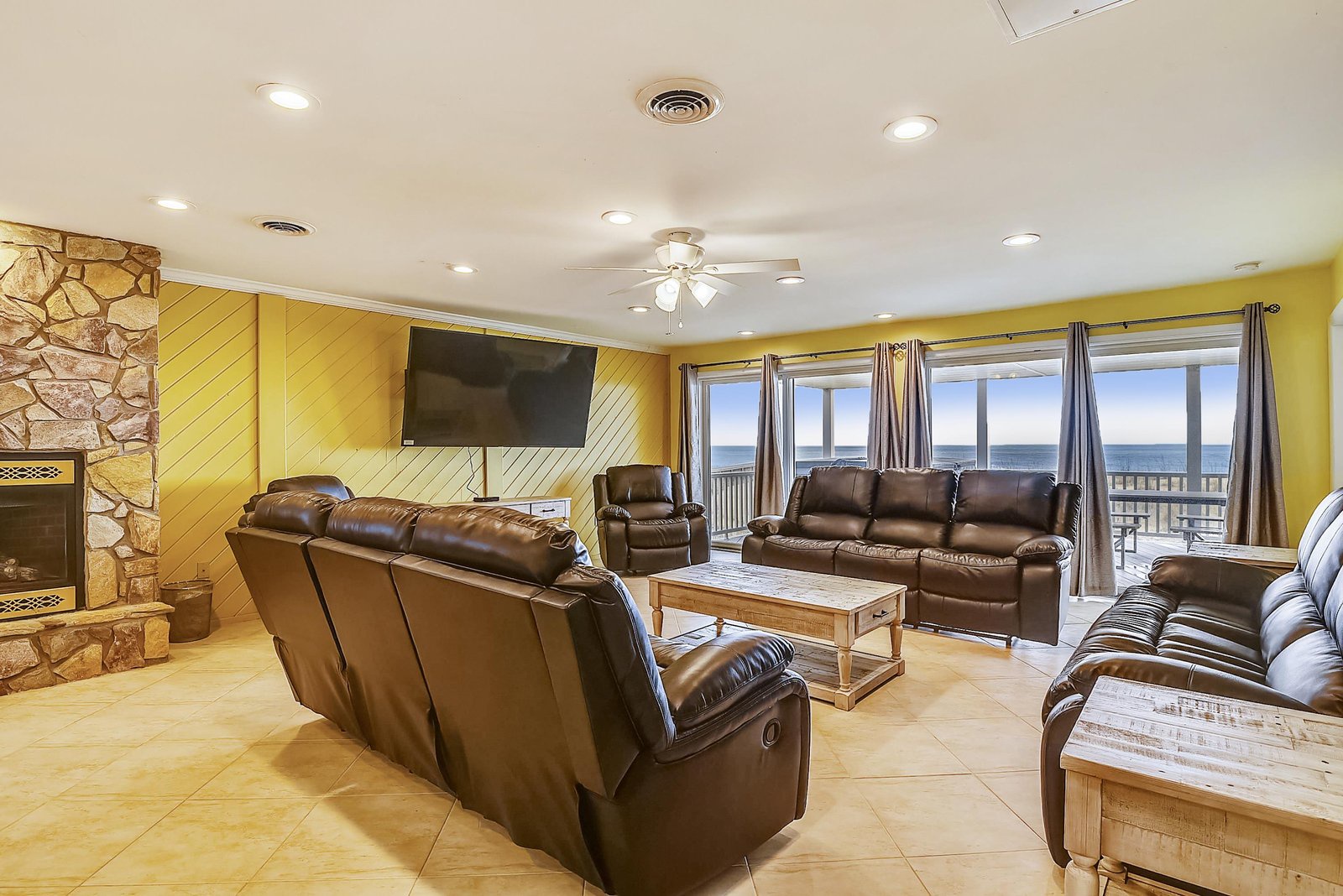 Sink into plush leather seating and let your gaze drift to the sparkling ocean just beyond your windows—this spacious living room pairs coastal views with cozy comfort for your perfect beach escape.