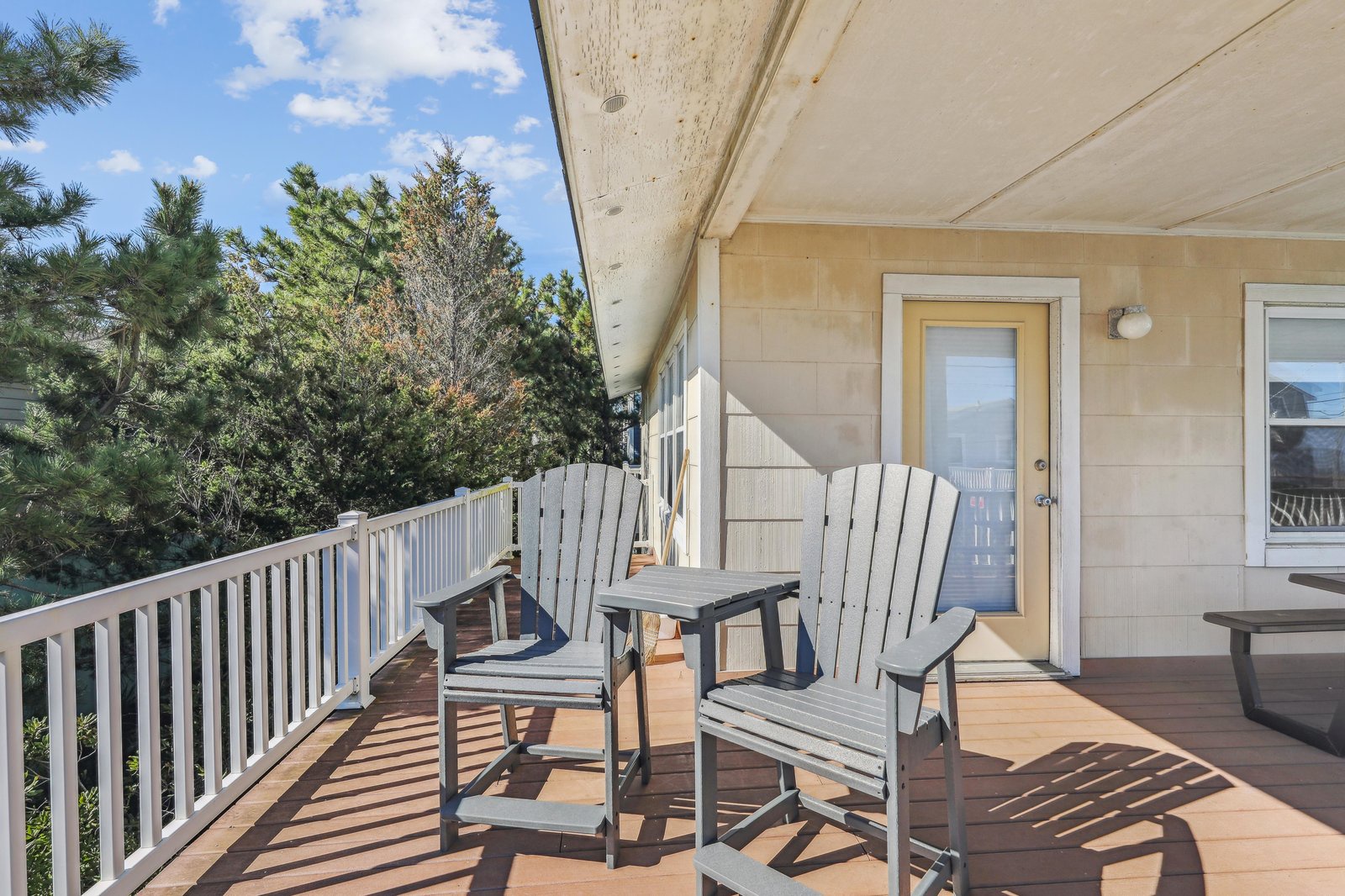A covered balcony where you can relax in Adirondack chairs surrounded by treetops and fresh air. Bright skies and peaceful views make this your own little sanctuary above it all.