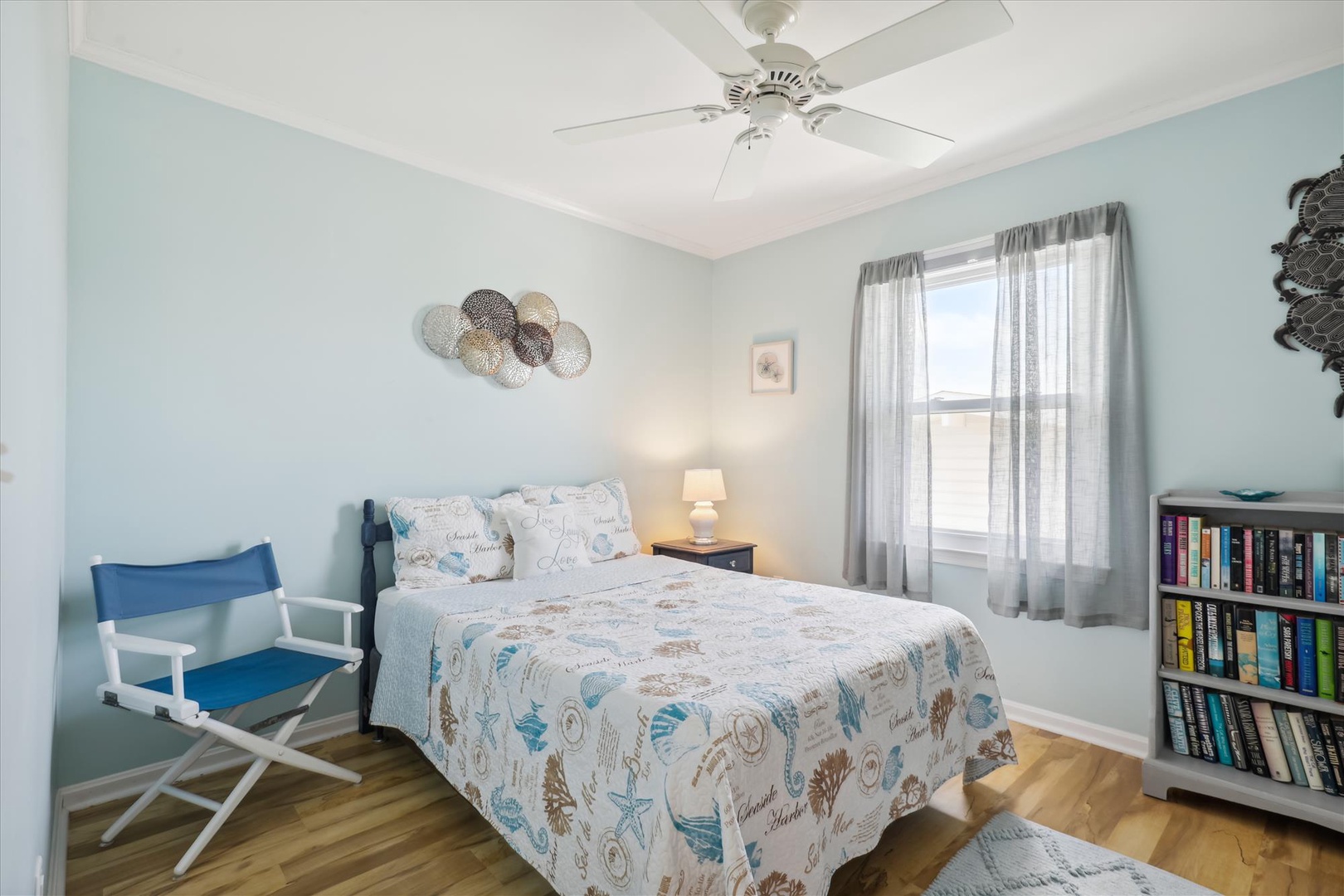 Unwind in your serene bedroom, where soft coastal hues and gentle light create a peaceful retreat. Relax under the ceiling fan after days spent exploring nearby beaches.